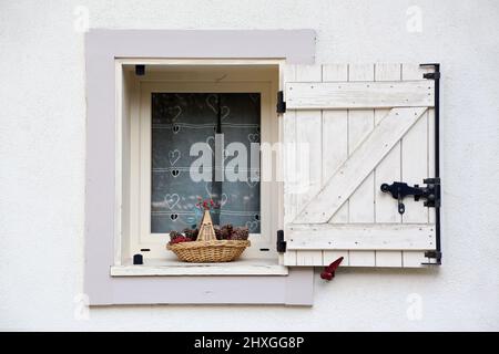 Panier en osier comprenant des pompes de PIN déposiées sur le bord d'une fenêtre. Saint-Gervais-les-bains. Haute-Savoie. Auvergne-Rhône-Alpes. Haute-sa Banque D'Images