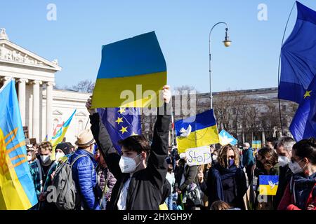 Sur la Königsplatz à Munich, un jeune homme tient une pancarte en carton aux couleurs nationales ukrainiennes lors de la manifestation contre la guerre à Ukrain Banque D'Images