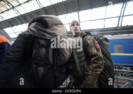 Lviv, Ukraine. 12th mars 2022. Un soldat ukrainien monte à bord d'un train à la gare de Lviv car beaucoup de personnes fuient vers les pays voisins dans le cadre de l'invasion russe, à Lviv, en Ukraine, le 12 mars 2022. (Image de crédit : © Bryan Smith/ZUMA Press Wire) Banque D'Images