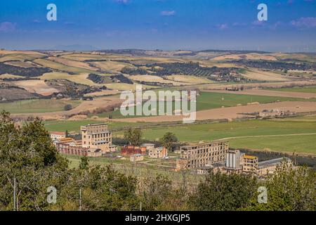 Les bâtiments d'une ancienne usine abandonnée et désaffectée, à la campagne, entre les collines et les champs cultivés, à la périphérie de Tarquinia. Vit Banque D'Images