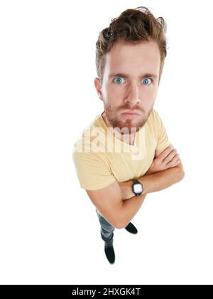 Vous donnant l'œil malin. Portrait studio d'un jeune homme en colère debout avec ses bras repliés sur un fond blanc. Banque D'Images