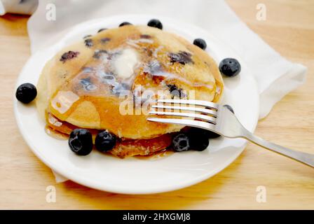 Manger des crêpes aux myrtilles avec beurre et sirop Banque D'Images