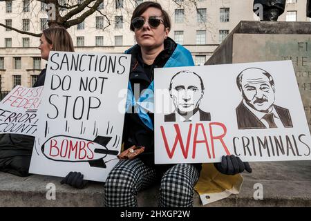 Londres, Royaume-Uni, 12th mars 2022. Ukraine les ressortissants et les partisans continuent de se rassembler à Whitehall, en face de Downing Street, et appellent à une action plus importante contre la Russie pour l'invasion de l'Ukraine par la communauté internationale. Le protestant tient la plaque pour inculper le président Vladimir Poutine et le ministre des Affaires étrangères Sergei Lavrov de crimes de guerre. Banque D'Images