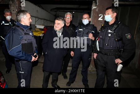 Velbert, Allemagne. 12th mars 2022. Herbert Reul (2nd de gauche), ministre de l'intérieur de la Rhénanie-du-Nord-Westphalie, est informé par des policiers de l'état d'un raid. La police a mené aujourd'hui des raids en Rhénanie-du-Nord-Westphalie sur des machines à sous illégales et du tabac non déclaré. Credit: Roberto Pfeil/dpa/Alay Live News Banque D'Images