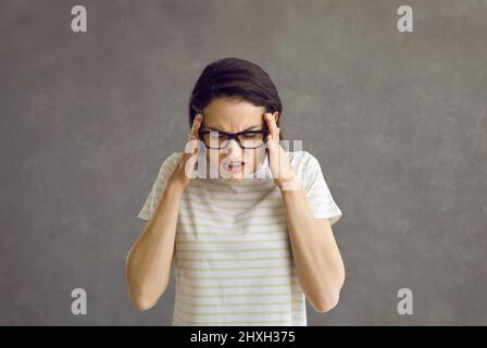 Stress malade jeune femme se sentant fort mal de tête terrible tir en studio Banque D'Images