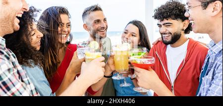 Jeunes amis multiethniques s'amuser tout en prenant des cocktails sur la terrasse Banque D'Images