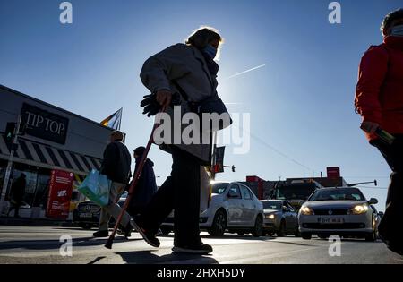 Bucarest, Roumanie - 19 janvier 2022 : des piétons traversent la rue près du marché de Crangagi à Bucarest, Roumanie. Banque D'Images