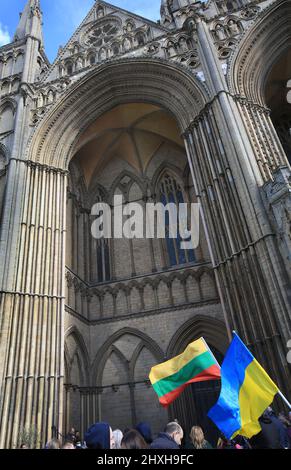 Peterborough, Royaume-Uni. 12th mars 2022. Les drapeaux lituanien et ukrainien sont ondulés devant la cathédrale. À une époque où l'Ukraine est attaquée par la Russie de Vladimir Poutine, les Lituaniens célèbrent leur restauration le jour de l'indépendance à la cathédrale de Peterborough. Ils soutiennent l'Ukraine et tiennent les drapeaux et rubans ukrainiens. La Lituanie a retrouvé sa liberté de l'Union soviétique le 11th 1990 mars. Une courte prière et un silence d'une minute ont été organisés pour les défenseurs de la liberté déchus. (Photo de Martin Pope/SOPA Images/Sipa USA) crédit: SIPA USA/Alay Live News Banque D'Images