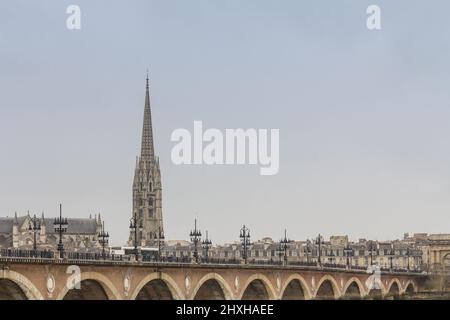 Photo d'un panorama nuageux de Bordeaux, France, avec le pont de pierre, ou pont de pierre, en face du clocher de la basilique saint michel. Banque D'Images