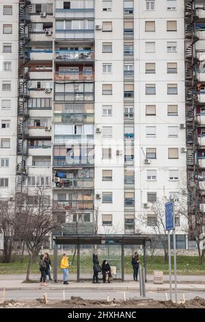 Photo des bâtiments socialistes de Novi Beograd à Blok 61 à Belgrade, Serbie avec des voitures et des gens passant à un arrêt de bus. Ils sont typiques de la c Banque D'Images