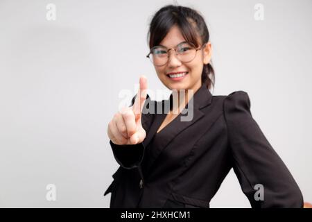 Les femmes asiatiques souriantes utilisent le symbole du premier doigt du salon de la main sur fond blanc Banque D'Images