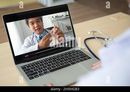 Asian femmes médecin regardant le tutoriel vidéo de médecins spécialisés dans la physiothérapie. Concept de l'apprentissage vidéo, de l'éducation et du développement personnel Banque D'Images