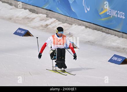 Zhangjiakou, province chinoise du Hebei. 13th mars 2022. Zheng Peng, de Chine, participe à la compétition de ski de fond mixte 4x2,5 km Relais des Jeux paralympiques d'hiver de Beijing 2022 au Centre national de biathlon de Zhangjiakou, dans la province de Hebei, dans le nord de la Chine, le 13 mars 2022. Crédit : MU Yu/Xinhua/Alay Live News Banque D'Images