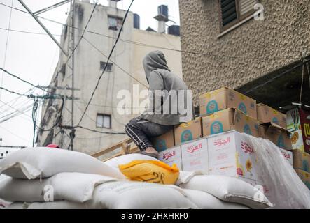 Gaza, Palestine. 12th mars 2022. Un travailleur palestinien assis sur des boîtes d'un moulin à blé, dans le nord de la bande de Gaza. Crédit : SOPA Images Limited/Alamy Live News Banque D'Images