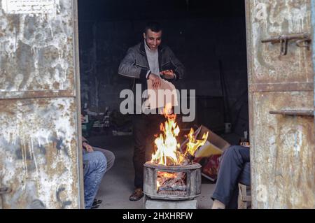 Gaza, Palestine. 12th mars 2022. Les réfugiés palestiniens se réchauffent par un incendie à l'extérieur de leur maison familiale par temps froid dans le nord de la bande de Gaza. Crédit : SOPA Images Limited/Alamy Live News Banque D'Images