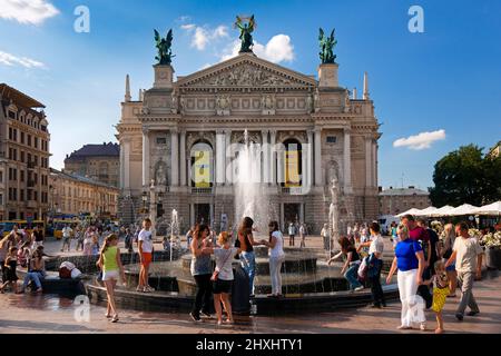 Ukraniens et touristes se détendant près de la fontaine en face de l'Opéra, centre de Lviv, Ukraine Banque D'Images