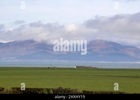 10 mars 2022 Une vue sur les montagnes Mourne avec leurs pics couverts de nuages. Vue de l'autre côté de la baie de Dundrm depuis la région de Killough dans le comté en bas de l'I du Nord Banque D'Images