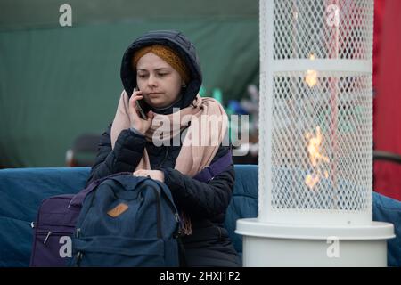 Medyka, Pologne. 13th mars 2022. Vira de Lviv est au téléphone juste après avoir traversé la frontière entre l'Ukraine et la Pologne. Les troupes russes ont envahi l'Ukraine le 24 février. Credit: Sebastian Gollnow/dpa/Alay Live News Banque D'Images