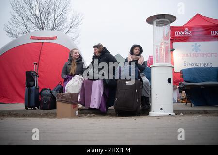 Medyka, Pologne. 13th mars 2022. Anastasia (l-r), sa mère Alla, qui a fui Sumy, s'assoit à côté de Vira de Lviv peu après le passage de l'Ukraine à la Pologne. Les troupes russes ont envahi l'Ukraine le 24 février. Credit: Sebastian Gollnow/dpa/Alay Live News Banque D'Images