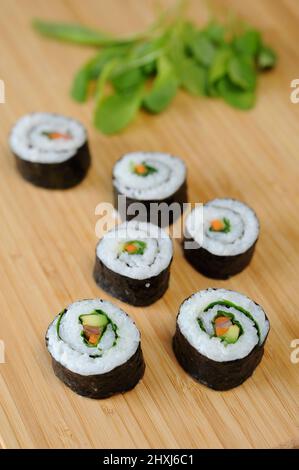 Rouleaux de sushi sur la planche à découper. Mise au point sélective. Banque D'Images