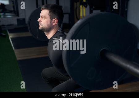 Homme ayant un entraînement de poids avec barbell dans la salle de gym Banque D'Images