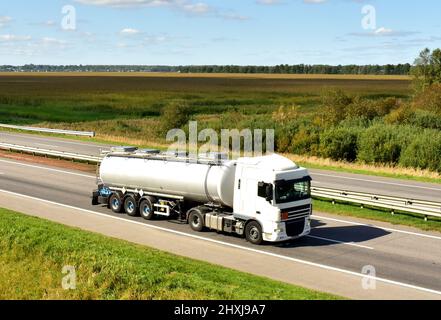 Camion-citerne isotherme conduisant sur autoroute. Transport et logistique du pétrole et du gaz. Citerne en métal chromé avec produits pétrochimiques. Produit chimique liquide F Banque D'Images