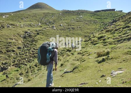 Vue arrière d'un touriste qui marche sur la montagne avec ses amis avec un sac à dos en parachute Banque D'Images