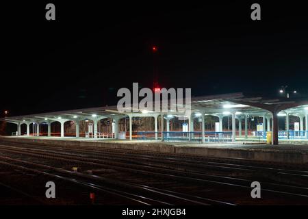 Gare, plates-formes de chemin de fer la nuit, illuminées par des lanternes électriques. Vous pouvez voir les étoiles dans un ciel sans nuages. Banque D'Images