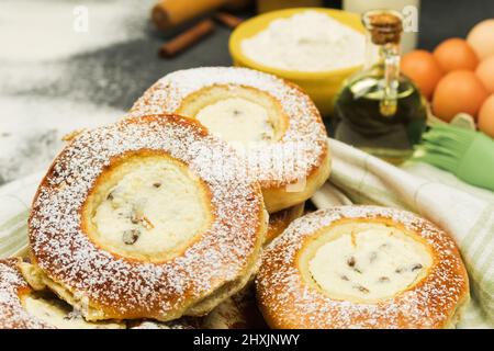 Pâtisseries fraîches sur fond d'ingrédients pour la cuisson. Petits pains fraîchement cuits sur une table en bois. Fond de cuisson, confiserie. Espace libre pour Banque D'Images