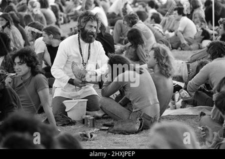 'Mick the Vic', qui est le Rév Michael Scott, Vicaire à l'église St Marc, Reading, visite le site du festival à la lecture, en lavant les pieds des fans de pop. 27th août 1976. Banque D'Images