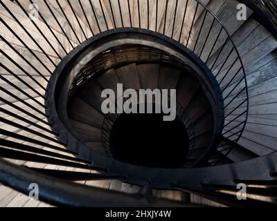 Escalier en colimaçon. Image d'un escalier en bois et en fer en spirale vers le bas, à l'obscurité. Banque D'Images