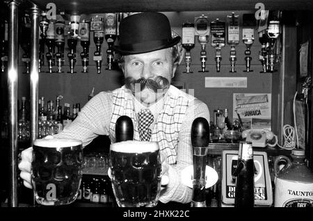 Bobby Moore se prépare à l'ouverture de sa propre maison publique appelée Moore's à Stratford Broadway, dans l'est de Londres. Il porte un chapeau de melon et une fausse moustache. Bobby Moore joue à Flo Fulham en ce moment. Photo prise le 17th novembre 1976 Bobby Moore se préparant à l'ouverture de sa propre maison publique appelée Moore's à Stratford Broadway, Londres est. Il porte un chapeau de melon et une fausse moustache. Bobby Moore joue pour Fulham à ce moment. Photo prise le 17th novembre 1976 Banque D'Images