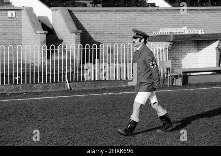 Freddie Starr, comédien, au club de football de Wimbledon, pour filmer son émission télévisée, Who Do You Do?, mercredi 14th janvier 1976. Notre image montre ... imitant Adolf Hitler. Banque D'Images