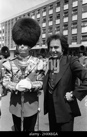 L'animateur Neil Diamond et Lord Tavistock (non représenté) présentent un chèque au bataillon 2nd, Grenadier Guards, à la caserne de Chelsea. Le chèque a été un « merci » pour la performance du corps des tambours au début du concert de samedi dernier à l'abbaye de Woburn, lorsque Diamond a joué à plus de 51 000 personnes. Il sera remis aux Fonds de la Division des ménages (appel du Jubilé d'argent), et est le produit de la vente des programmes Neil Diamond au concert. 7th juillet 1977. Banque D'Images