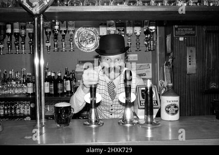 Bobby Moore se prépare à l'ouverture de sa propre maison publique appelée Moore's à Stratford Broadway, dans l'est de Londres. Il porte un chapeau de melon et une fausse moustache. Bobby Moore joue à Flo Fulham en ce moment. Photo prise le 17th novembre 1976 Bobby Moore se préparant à l'ouverture de sa propre maison publique appelée Moore's à Stratford Broadway, Londres est. Il porte un chapeau de melon et une fausse moustache. Bobby Moore joue pour Fulham à ce moment. Photo prise le 17th novembre 1976 Banque D'Images