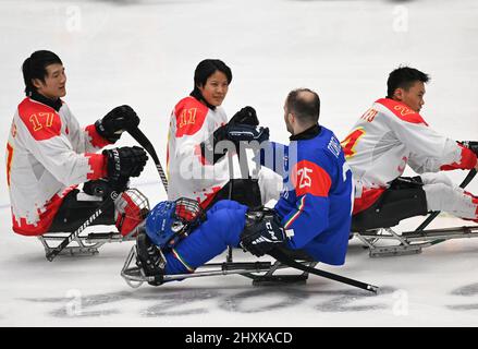 (220313) -- BEIJING, 13 mars 2022 (Xinhua) -- Yu Jing (2nd L) de Chine accueille Francesco Torella (2nd R) d'Italie après le match préliminaire de hockey sur glace du groupe B entre la Chine et l'Italie des Jeux paralympiques d'hiver de 2022 à Beijing au Stade national intérieur de Beijing, le 8 mars 2022. (Bowen Xinhua/Zhang) Banque D'Images