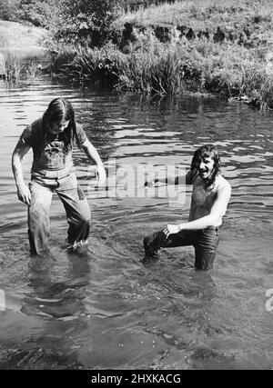 Les membres du groupe Heavy Metal Black Sabbath qui se débatent sur la rivière dans la pittoresque vallée de Wye.Ozzy Osbourne et Geezer Butler obtiennent un trempage. 10th août 1977 Banque D'Images