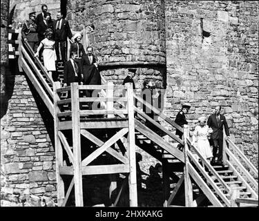 La reine Elizabeth II et le duc d'Édimbourg mènent la fête sur les marches en bois tandis que la fête quitte le château de Harlech, Llandudno. WalesThe Queen portait un haut bleu clair, une jupe et un chapeau blanc. La Reine est en tournée du Jubilé d'argent au pays de Galles. 1977. Photo prise le 22nd juin 1977. Banque D'Images