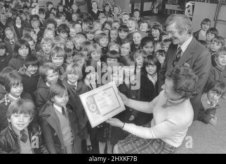 La dernière présentation de l'année du jubilé de l'épargne nationale à une école du South Warwickshire est tombée à la première école de Lillington C of E, à Leamington. Sur la photo, M. Anthony Butcher et la maîtresse Miss J. Williams montrent aux enfants le certificat de contribution de 69 ans au mouvement. 7th décembre 1976 Banque D'Images