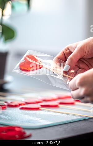 Conditionnement de sucettes rouges en forme de coeurs. Banque D'Images