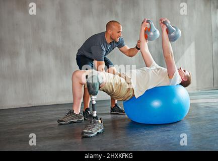 Concentrez-vous sur le haut du corps. Studio de tournage d'un entraînement de jeune amputé dans une salle de sport. Banque D'Images