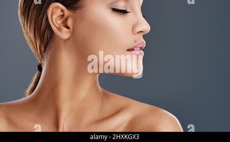 Sa peau est absolument lumineuse. Photo courte d'une belle jeune femme posant dans le studio. Banque D'Images