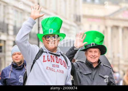 Londres, Royaume-Uni. 13th mars 2022. Deux visiteurs américains s'y joignent pour s'amuser. Les participants et les spectateurs s'amusent au défilé du maire de Londres à la Saint-Patrick dans le centre de Londres avec des groupes de marche, des danseurs et des fanfares, malgré le temps. Il y a aussi une scène, des stands et des spectacles sur Trafalgar Square. Credit: Imagetraceur/Alamy Live News Banque D'Images