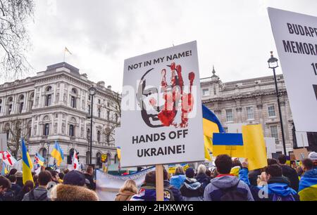 Londres, Royaume-Uni. 13th mars 2022. Un manifestant tient un écriteau « mains off Ukraine » avec le visage de Vladimir Poutine. Des milliers de manifestants se sont rassemblés devant Downing Street pour soutenir l'Ukraine tandis que la Russie poursuit son attaque. Credit: Vuk Valcic/Alamy Live News Banque D'Images