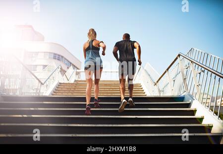 Renforcer leur forme physique. Vue arrière de deux jeunes qui font un jogging dans un escalier extérieur. Banque D'Images