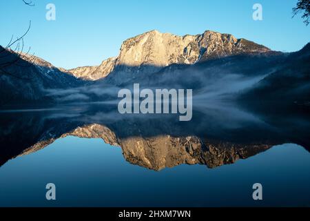 La montagne de Trisselwand se reflète dans le lac de l'Altaussee l'après-midi d'hiver Banque D'Images