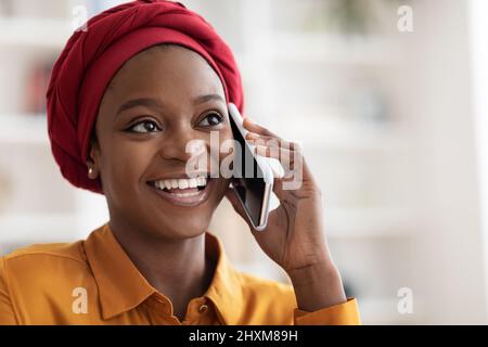 Gros plan sur une femme afro-américaine heureuse qui parle au téléphone Banque D'Images