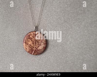 collier avec pendentif de texture de feuilles d'argile polymère fait main Banque D'Images