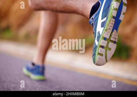 Mon mode de transport préféré. Photo d'un homme en train de courir le long d'une route. Banque D'Images