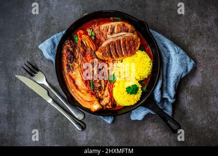 Canard grillé au chou de napa et au riz safran dans une poêle en fonte Banque D'Images